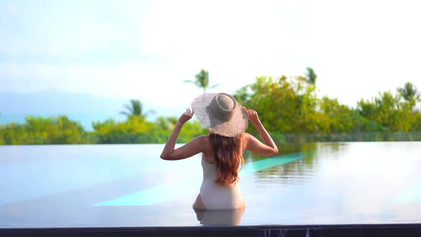 Young asian woman enjoy around outdoor swimming pool for leisure