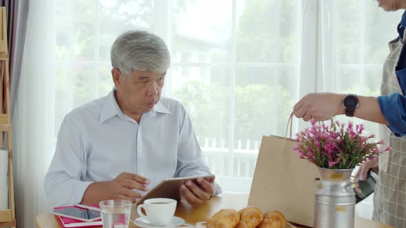 Senior man paying order with smart watch in coffee shop