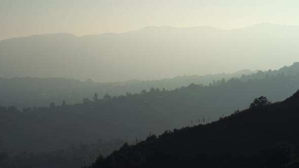 Time Lapse of Sun Setting Behind Mountain and Heavy Atmosphere