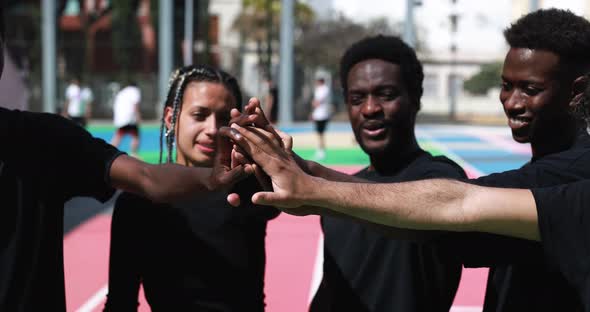 Group of young multiracial people stacking hands outdoor