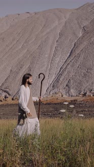 Jesus with Staff Walks on the Grass Against the Background of the Year