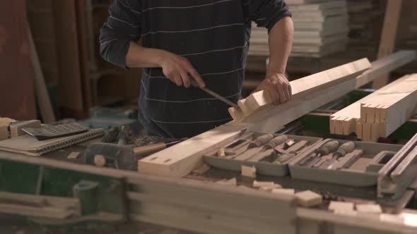 Carpenter polishing the ends of a timber