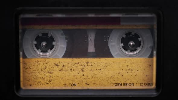 Vintage Yellow Audio Cassette Playing in Deck of an Old Tape Recorder