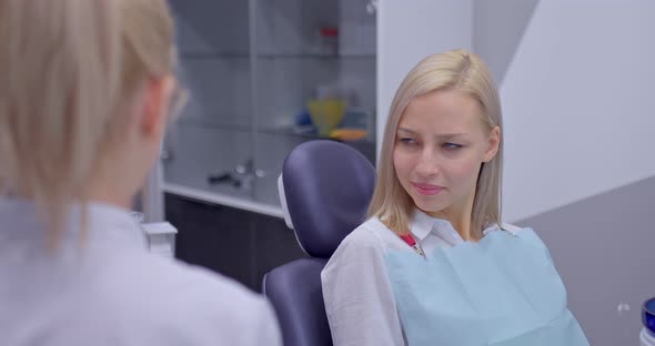 Beautiful Young Woman is Sitting at a Dentist Consultation and Smiling