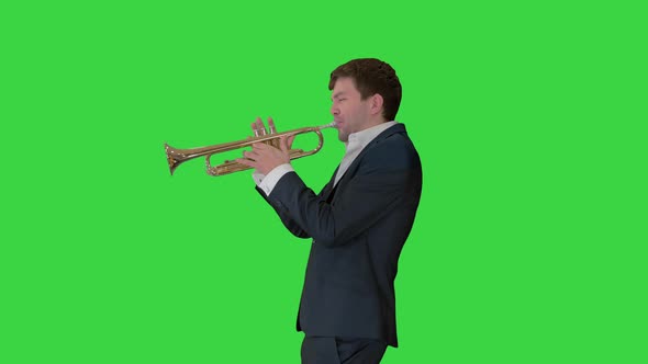 Man in Suit Standing Playing Trumpet on a Green Screen, Chroma Key.