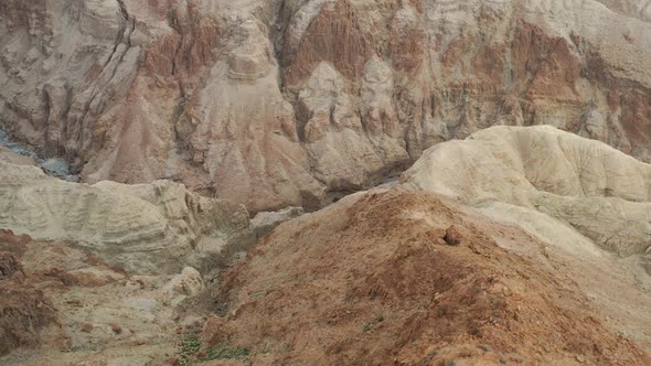 Aerial  fly over a creek between red desert mountains in Israel Judea desert