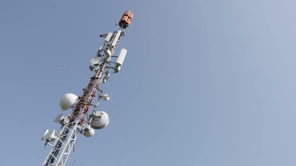 Against blue sky  telecommunication repeater antenna system  background 4K 3840X2160 UHD panning foo