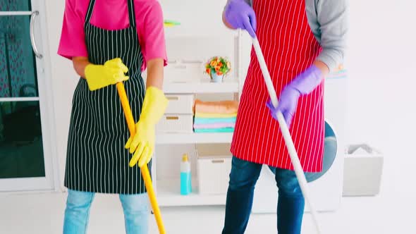 Husband and wife cleaning their room. Happy Asian couple spending time together at home.