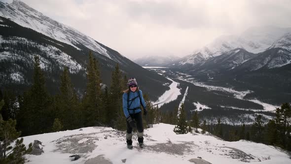 Young Female Hiker Smiles and Climbs a Snowy Mountain in Banff National Park. Outdoor Tourist Visits