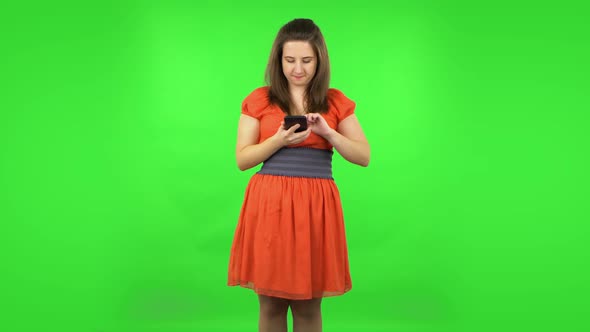 Cute Girl Making Selfie on Mobile Phone Then Looking Photos. Green Screen