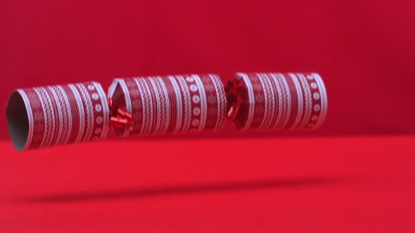 Christmas cracker dropping and bouncing on red background