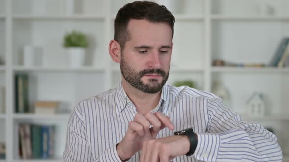 Portrait of Attractive Young Man Using Smart Watch