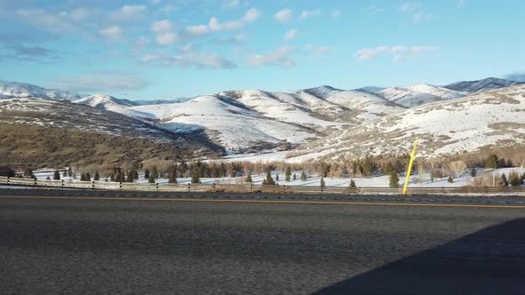 driving side view of snow capped mountains in utah