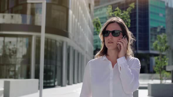 businesswoman talking on cellphone with walking city street.  