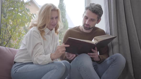 Mature Caucasian Woman Looking Photos with Adult Gray-haired Man