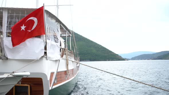 Motor Boat with a Turkish Flag is Moored Off the Coast of Perast