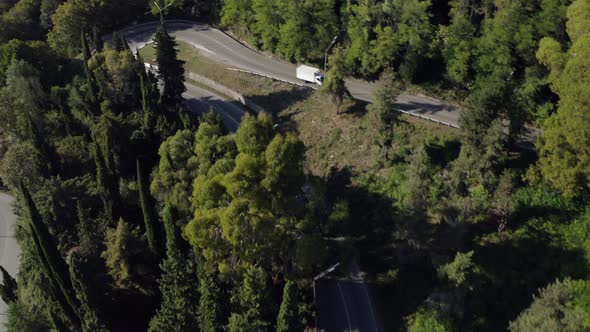 Aerial View Blue Passenger Bus Riding on Asphalt High Speed Road Beautiful Green Forest Trees