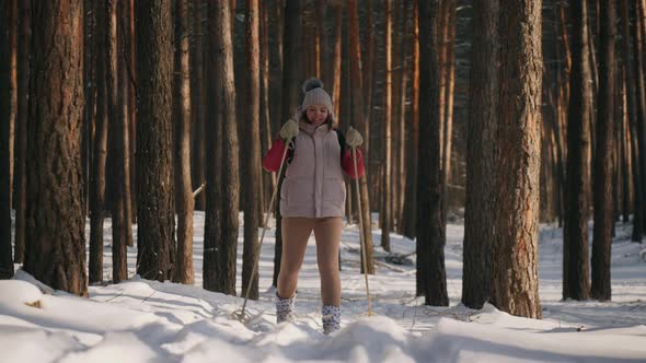 Happy Woman Skiing in Pine Forest on Sunny Frosty Day