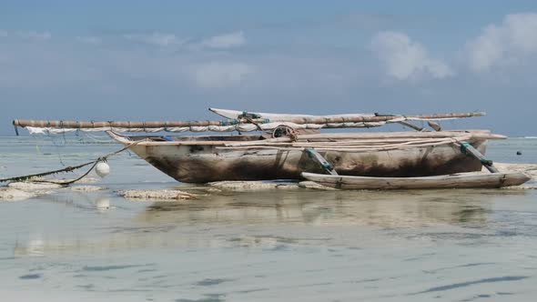 African Traditional Wooden Boat Stranded in Sand on Beach at Low Tide Zanzibar
