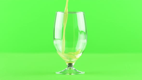 Juice Pouring Into Goblet Isolated on Light Green Background