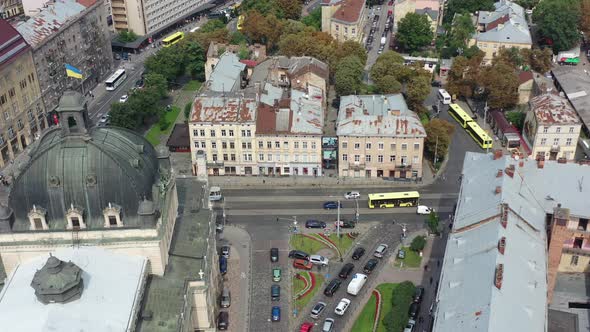 Ukraine flag waving on top of the Lviv National Academic Opera and Ballet Theatre with cars sitting