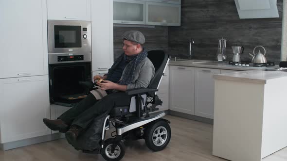 Man in Wheelchair Eating Cookies from Oven