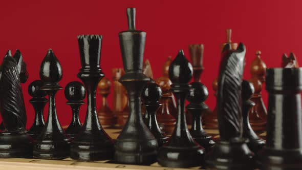 Wooden Chess Pieces on Chessboard Spinning on Red Background