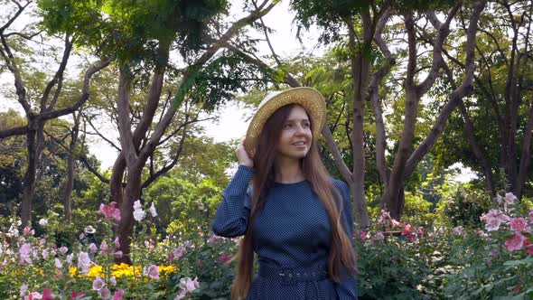 Happy Travel Woman Walking Leisure in Garden with Pink Flowers and Green Grass