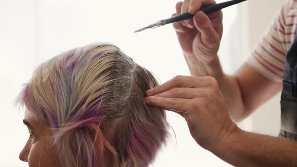 Side view woman having her hair styled by a hairdresser