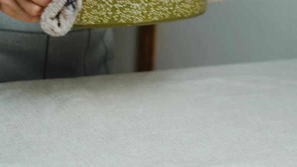 Female Hands Puts Banana Bread on Dinner Table Closeup