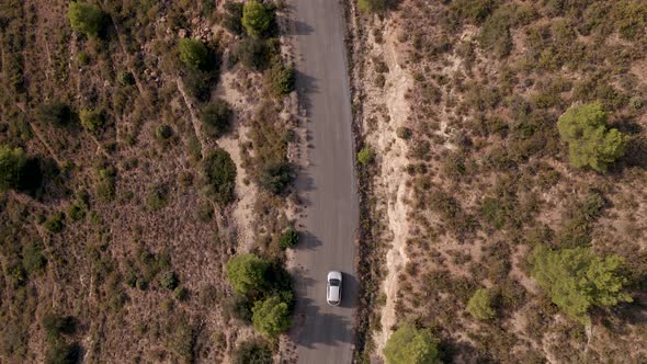 Drone Shot of a Car Passing on a Mountain Road on the Golden Hour