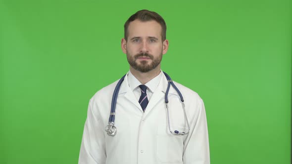 Handsome Doctor Looking at Camera Against Chroma Key