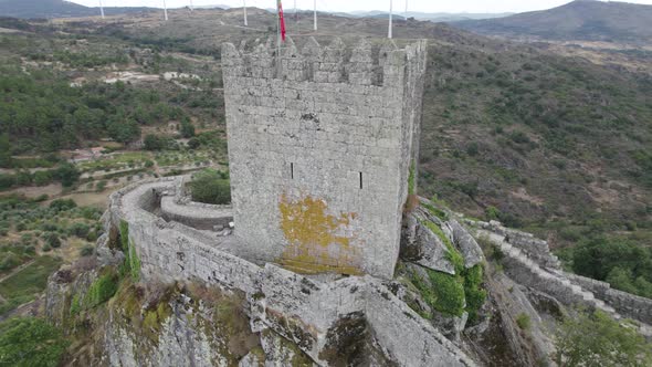 Sortelha medieval castle or Castelo de Sortelha with portuguese flag on top. Aerial drone circling