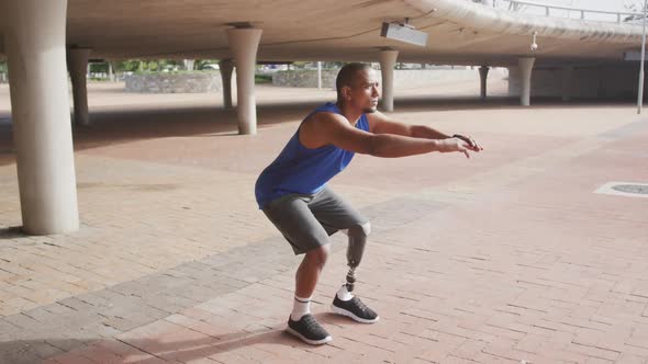 Side view man with prosthetic leg doing squats