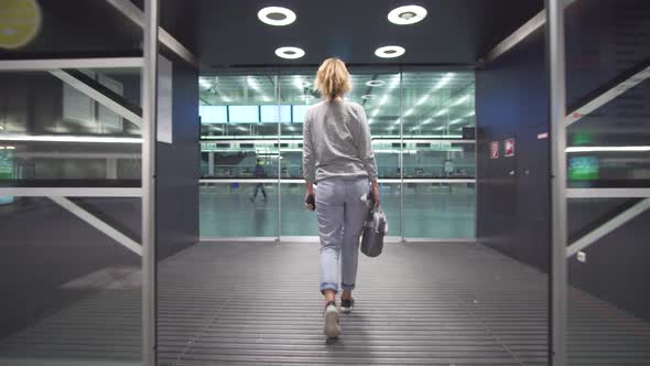 Female Passenger Traveler Checking Information of Boarding Pass Ticket and on Schedule Board