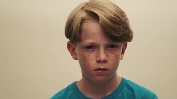 A close-up view of a surprised little boy is opening his eyes