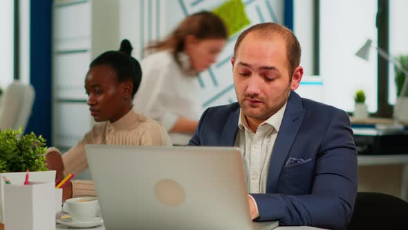 Busy Business Man Using Laptop Typing Sitting at Conference Table in Broadroom