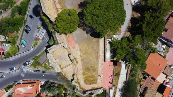 Top down aerial view of the highest point on the mountain hill surrounded by winding road, orange ho