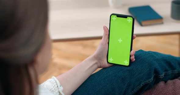 Backside View of Woman Holding and Looking at Smartphone Green Screen. Deaf Female Person Having