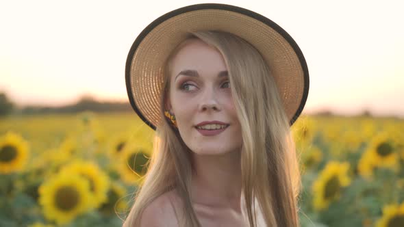 Happy Smiling Girl Looking in Camera in Field Sun is in Background