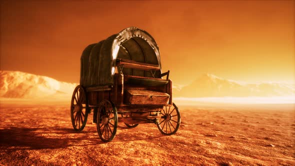 Canvas Covered Retro Wagon in Desert at Sunset