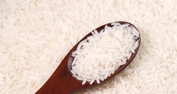 Uncooked White Rice and Wooden Spoon