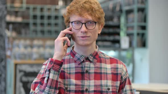 Young Redhead Man Talking on Smartphone