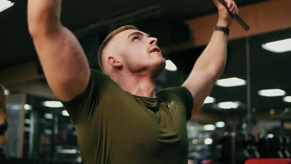 Young Handsome Blonde Man Iexercising His Chest Muscles and Training His Shoulders in the Gym