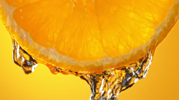 Super Slow Motion Macro Shot of Flowing Water From Fresh Orange Slice at 1000Fps