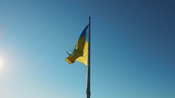 Ukraine Flag On A Background Of Blue Sky And Sun