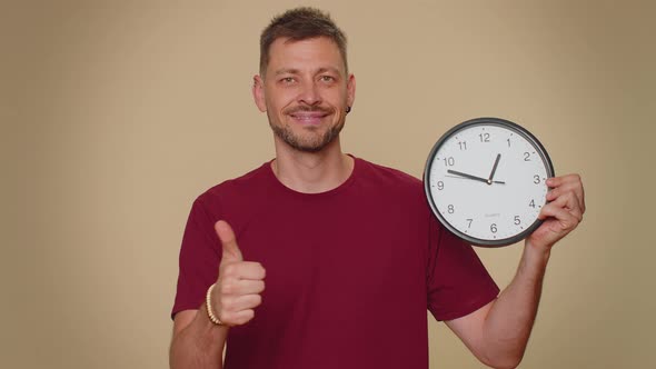 Handsome Man Showing Time on Wall Office Clock Ok Thumb Up Approve Pointing Finger at Camera