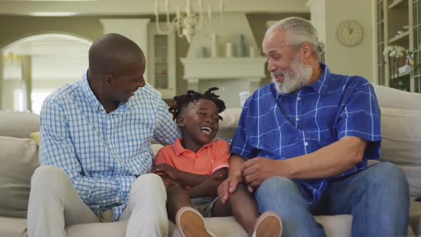 Senior African American man, his son and grandson spending time at home together.