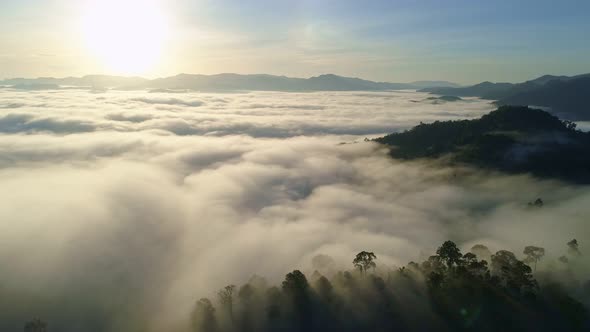 Aerial view Drone flying through the fog above mountain peak