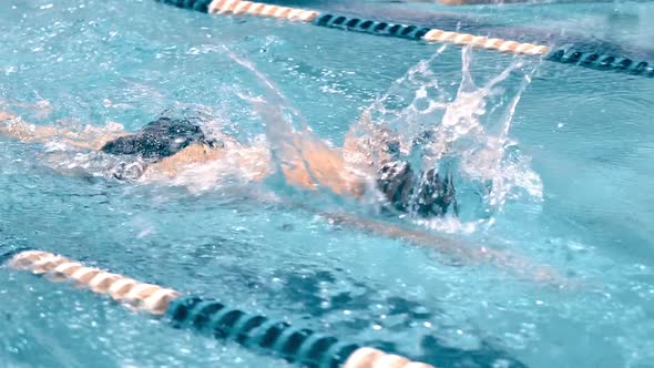 Powerful Professional Male Swimmer in Training Doing Crawl Stroke and Turning Up Head for Air